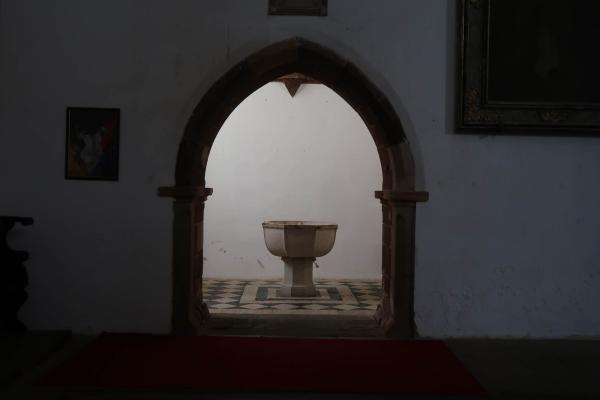 Ein Taufstein in einer Seitenkapelle einer Kirche