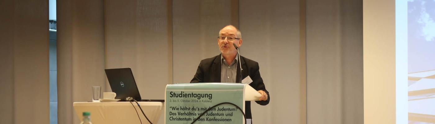 Prof. Rutishauser beim Vortrag am Lesepult