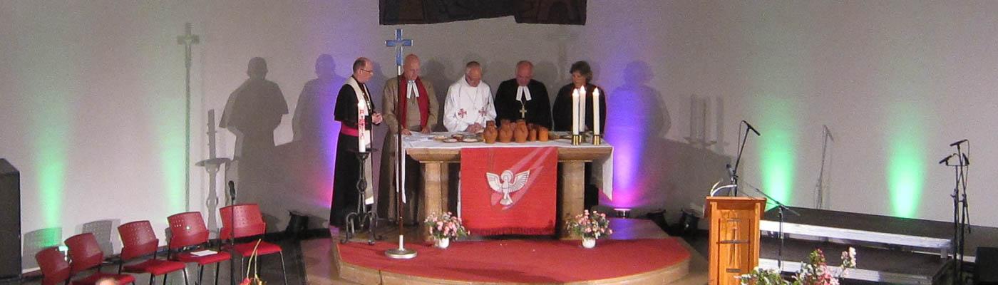 Geistliche versch. Konfessionen hinter dem Altar