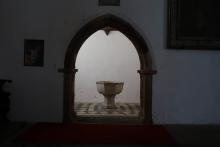 Ein Taufstein in einer Seitenkapelle einer Kirche